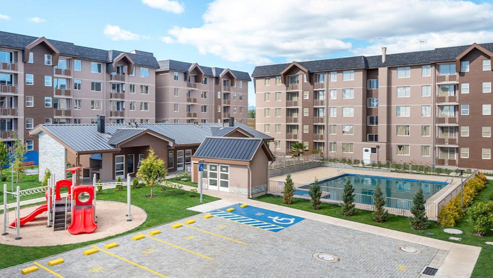 an apartment complex with a playground and a pool at Departamento en Villarrica con Piscina y Estacionamiento Privado in Villarrica