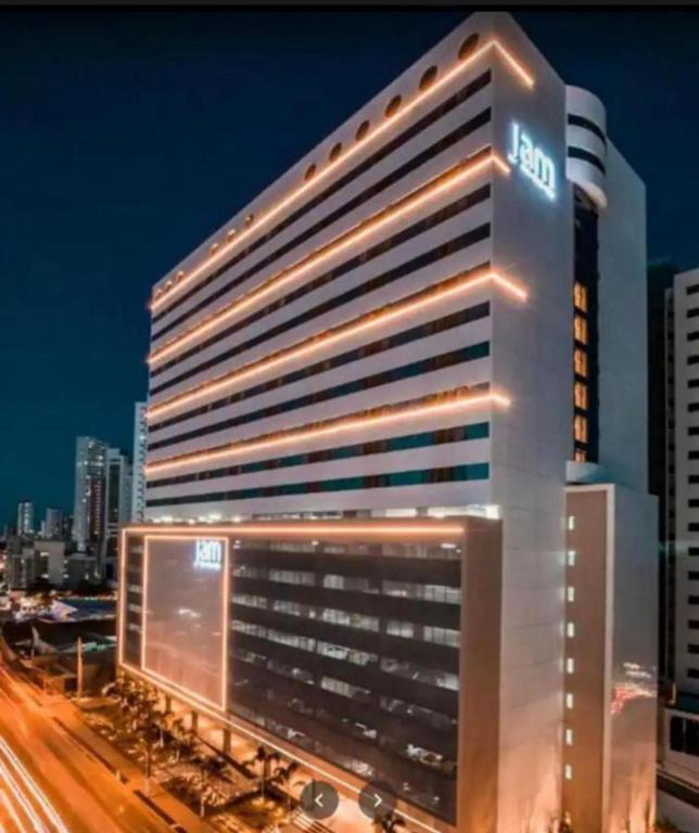 a lit up building in a city at night at Flat beira mar Olinda Jam in Olinda