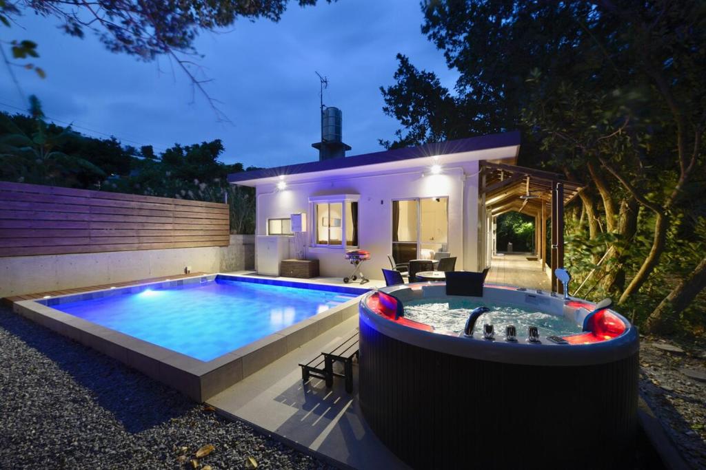 a swimming pool in front of a house at 064Villa 美海璃 in Nanjo