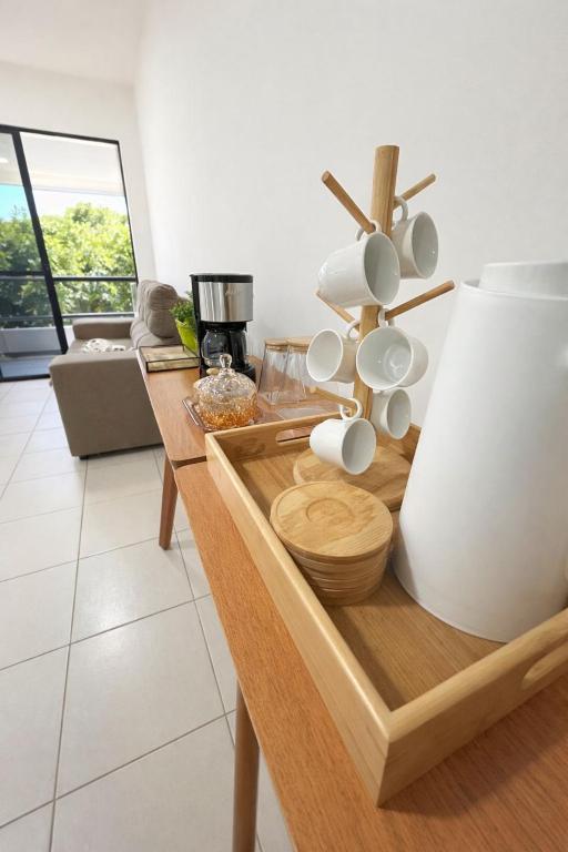 a living room with a table with mugs on it at Cantinho da Aruana, conforto e tranquilidade in Aracaju