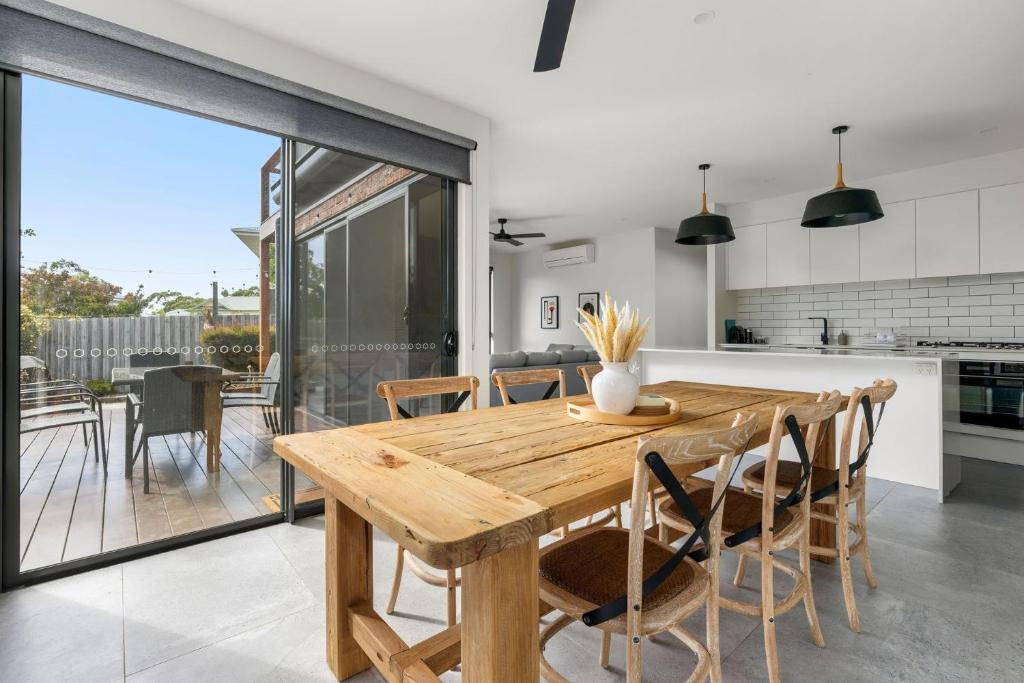 a kitchen and dining room with a wooden table and chairs at Coastal Ember in Inverloch