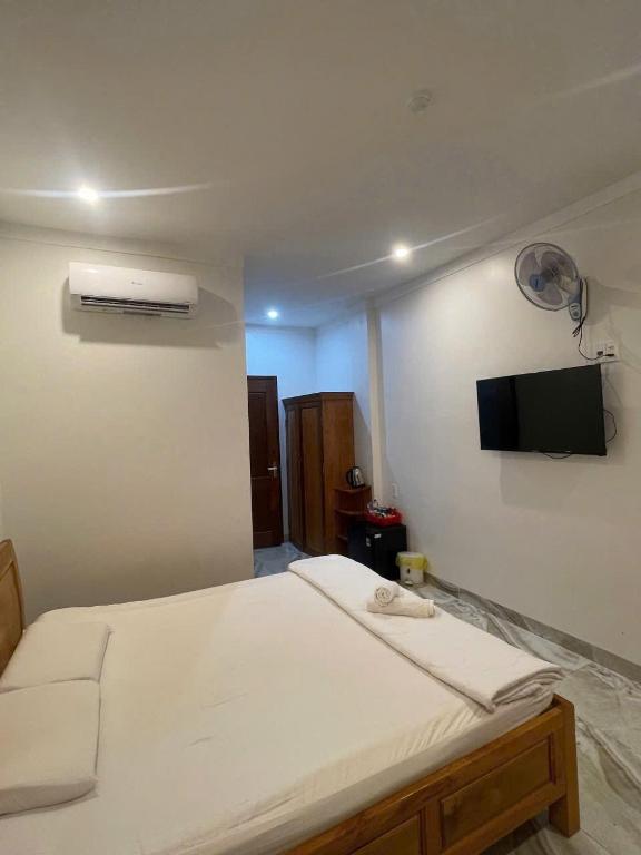 a bedroom with a bed with a tv on the wall at Khách sạn Kiến Đức in Kiến Ðức