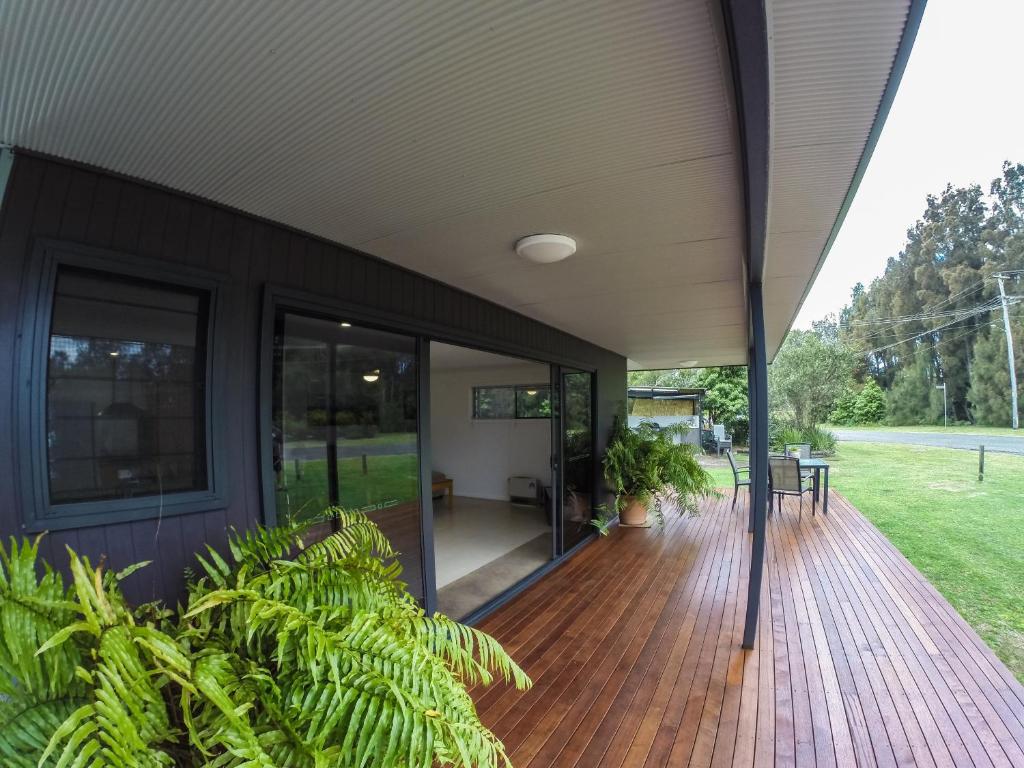 an exterior view of a house with a wooden deck at Rocketz at Berrara Beach in Sussex Inlet