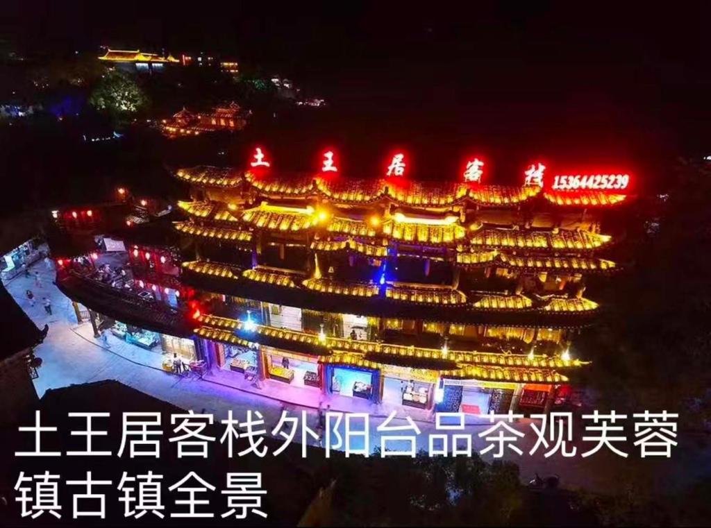 a chinese building at night with writing on it at Tu Wang Ju Ke Zhan in Yongshun