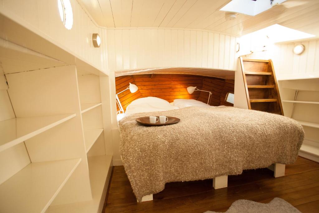 een kleine slaapkamer met een bed en een ladder bij Prince Royal B&B in Amsterdam