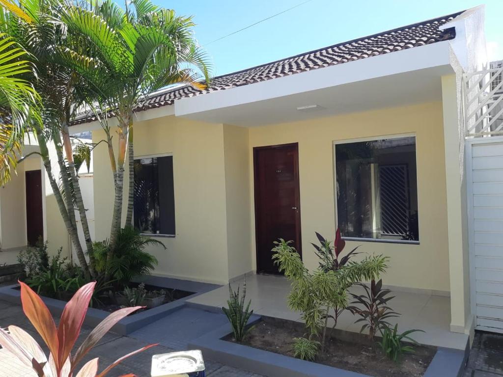 a home with palm trees in front of it at CASA DE PRAIA EM PRAIA BELA PITIMBu PB in Pitimbu