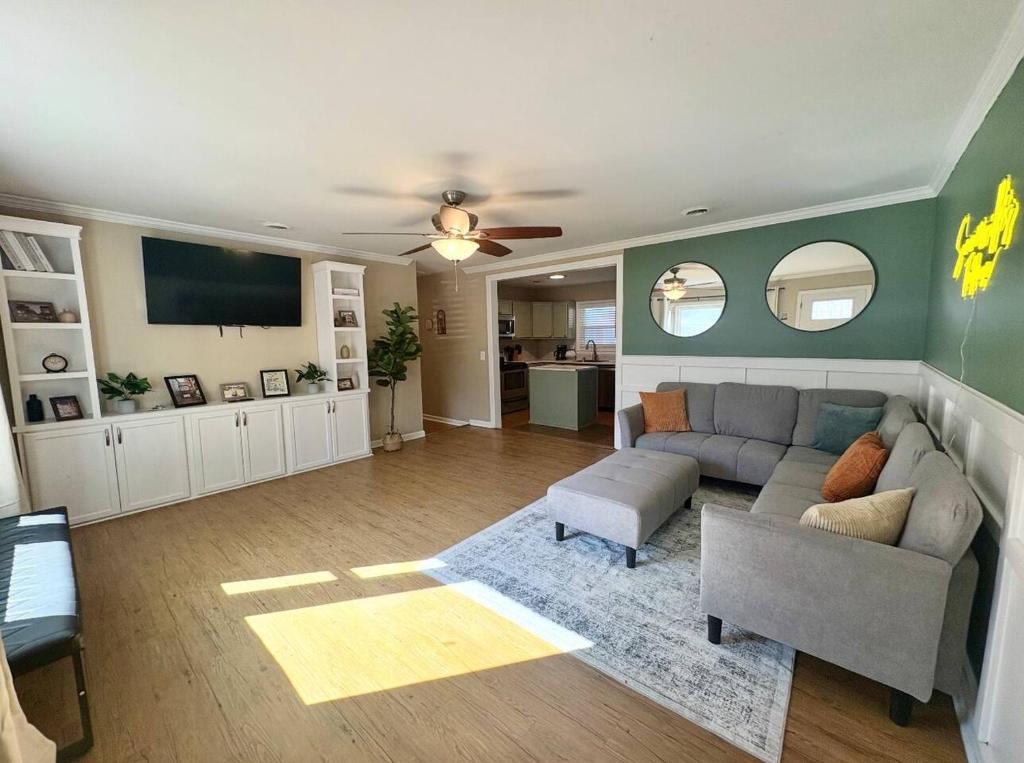 a living room with a couch and a flat screen tv at Summerville’s Tea House in Summerville
