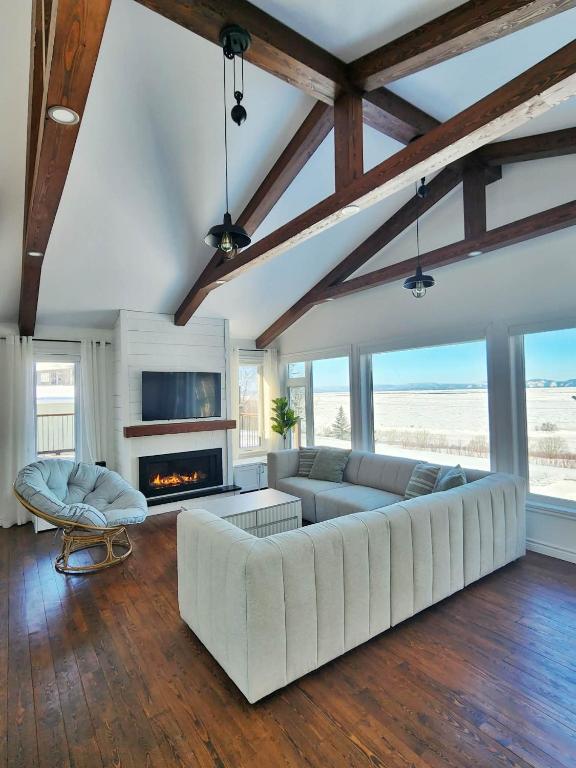 a living room with a white couch and a fireplace at L'Anseau-Persil in Rivière-du-Loup