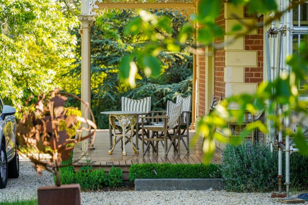 a wooden deck with a table and chairs on a house at St Agnes by Prunella in Kyneton