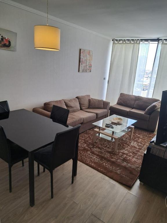 a living room with a couch and a table at Agradable Dpto Calama Centro in Calama