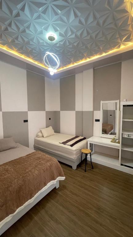 a bedroom with two beds and a blue ceiling at Homestay Yaa Syafi in Bireun