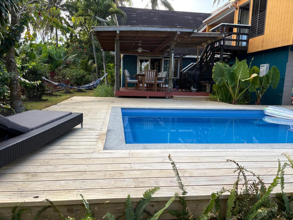 a backyard with a swimming pool and a house at Sea Turtle Lodge and Villas in Rarotonga