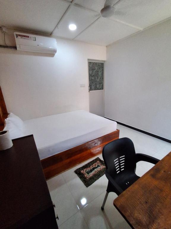 a bedroom with a bed and a desk and a chair at Beach cabin uppuveli in Trincomalee