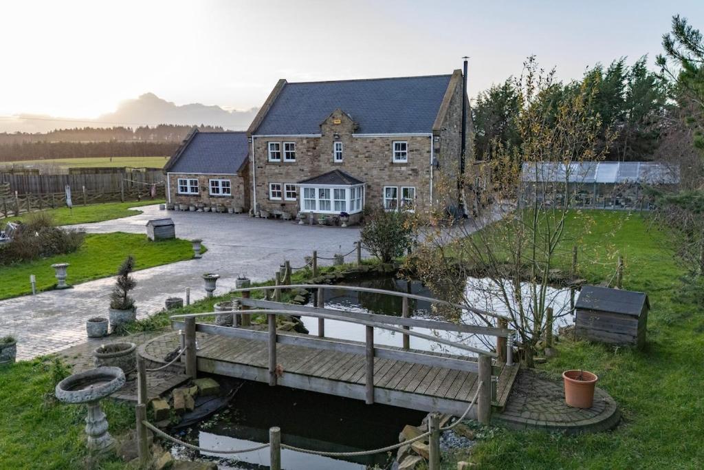 an old building with a bridge over a river at Waterside Equestrian Lodge in Durham