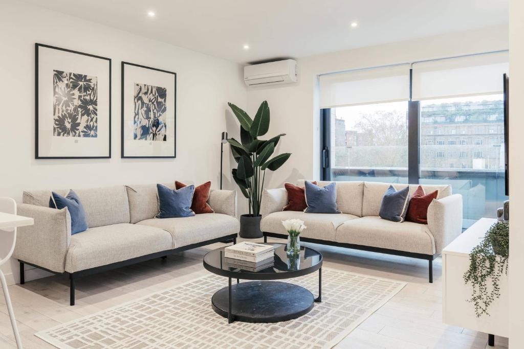 a living room with two couches and a table at Urban Rest Camden Town in London