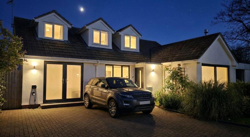 a car parked in front of a house at night at Croyde Broadlands 5 Bedrooms in Croyde