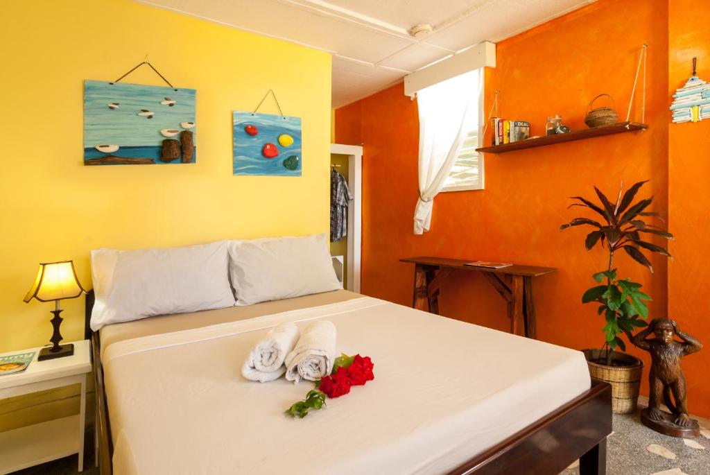 Un dormitorio con una cama con toallas y flores. en Kurma Eco Beach Lodge en Mambajao