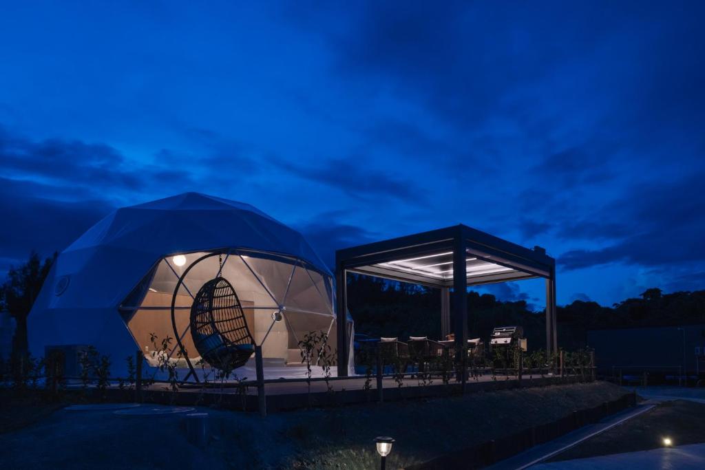 a tent with a table and chairs at night at glampark Sesoko -Ocean Terrace- in Sesoko