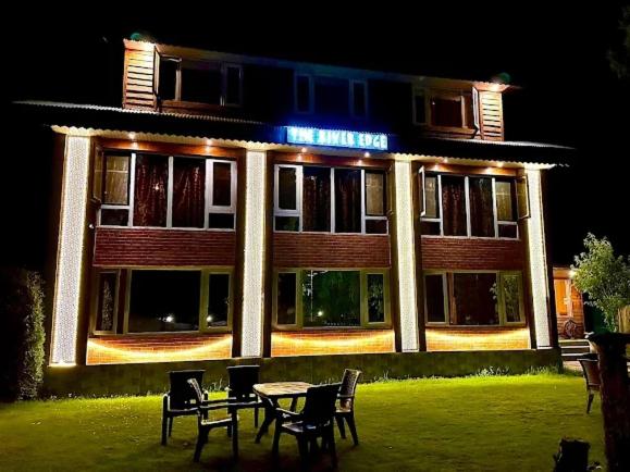 a building with a table and chairs in front of it at The River Edge in Pahalgām
