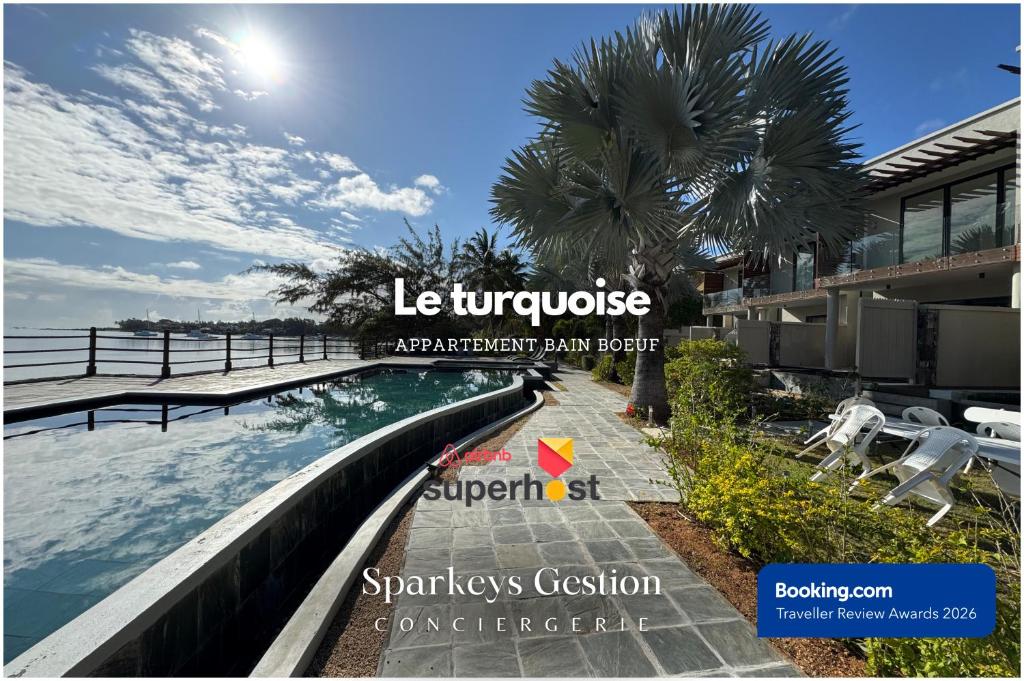 a swimming pool at a resort with a palm tree at SG5 l Le Turquoise - third line building - Beachfront Residence in Cap Malheureux