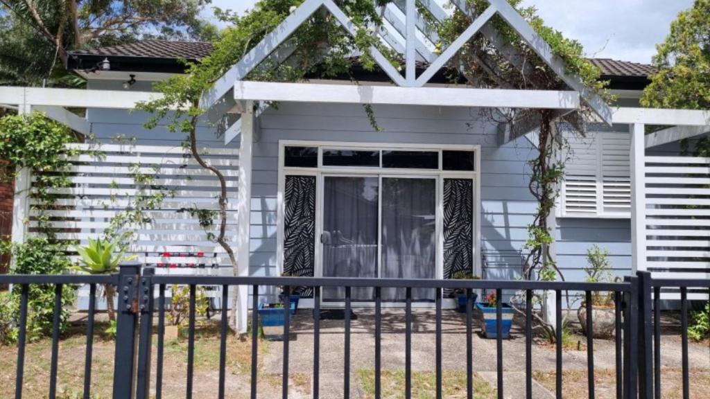 a house with a fence in front of it at There's Room For All in Hawks Nest