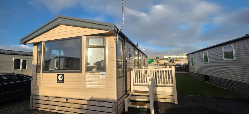 a tiny house with a porch and a trailer at Mason's Morecambe Memories in Heysham