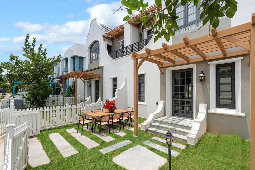 a patio with a wooden table in front of a house at Golden Terra Villa in Phan Thiet