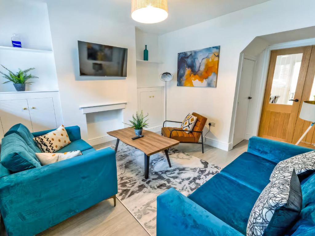 a living room with blue couches and a table at Woods Terrace in Gainsborough