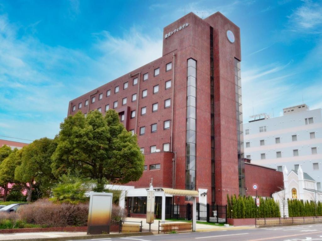 a red brick building with a clock tower at Kurayoshi City Hotel in Kurayoshi