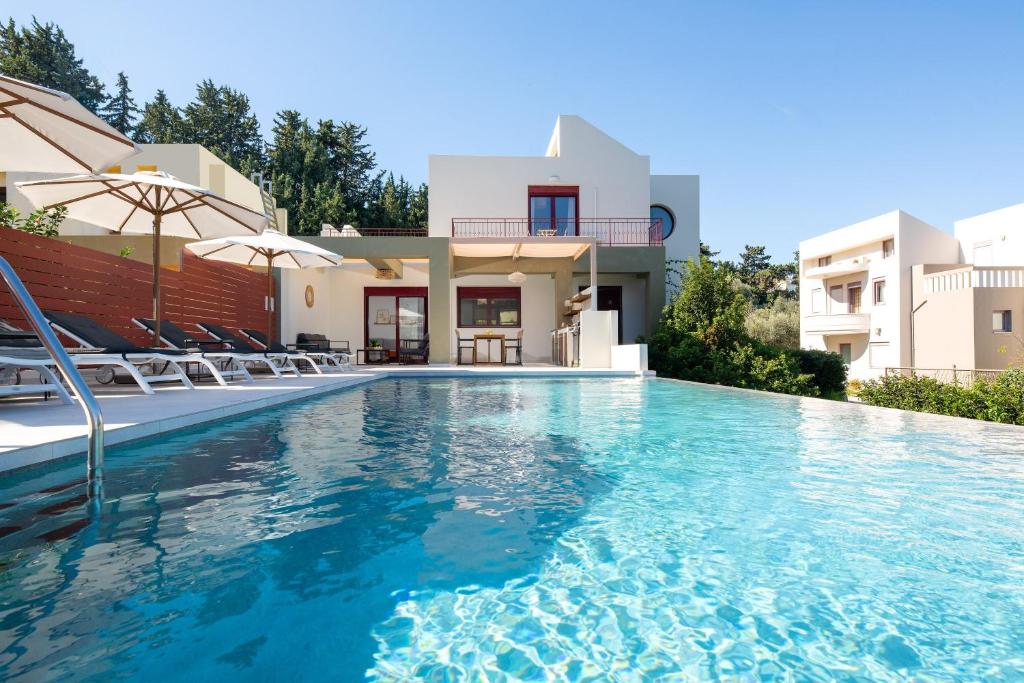 a swimming pool in front of a villa at Cicada Villa in Koskinou