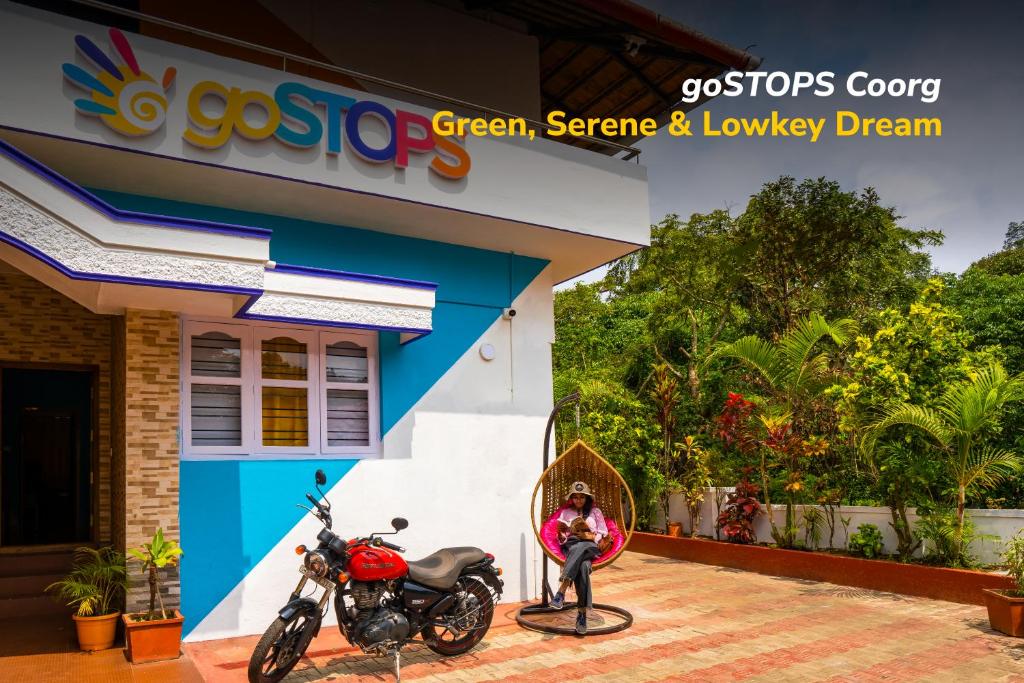 a man sitting on a motorcycle outside of a store at goSTOPS Coorg in Madikeri