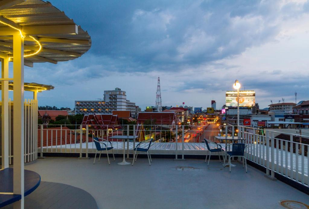 a balcony with chairs and a view of a city at The Moon Hostel Huahin in Hua Hin
