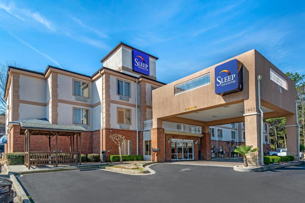 a hotel with a sign on the front of a building at Sleep Inn & Suites Stockbridge Atlanta South in Stockbridge