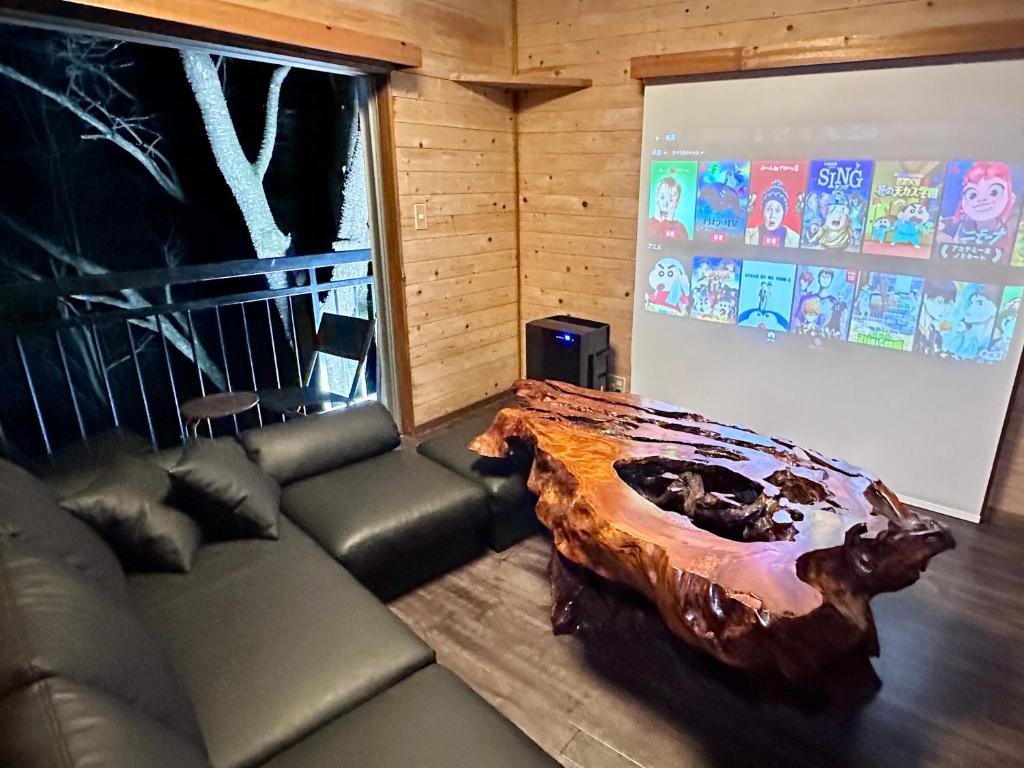 a living room with a couch and a large tree stump at Gen-en Private Hideaway Villa, Izu Forest in Izu