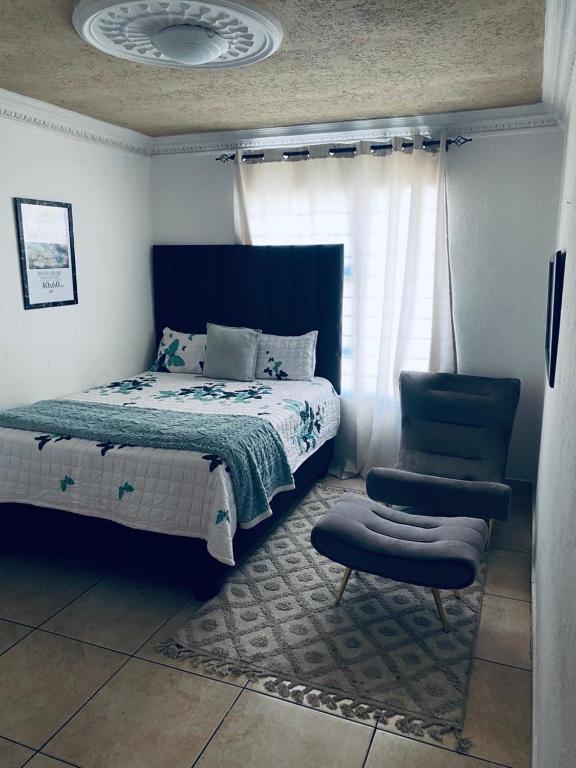 a bedroom with a bed and a chair at Euphoria Escape in Midrand