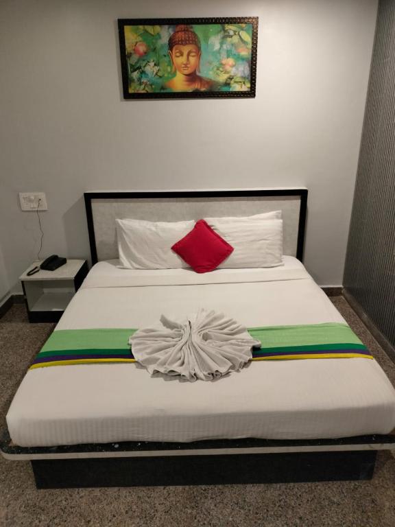 a bedroom with a bed with a painting on the wall at Hotel Vaishnavi in Hyderabad