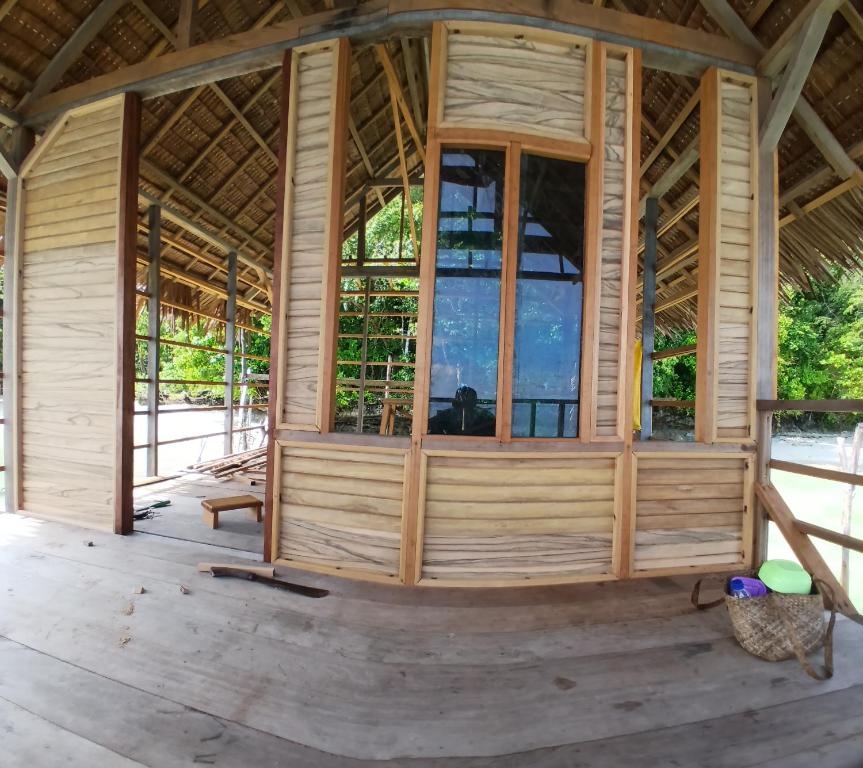 an inside view of a wooden house with large windows at Homestay Yenkop in Poelau Mansoear