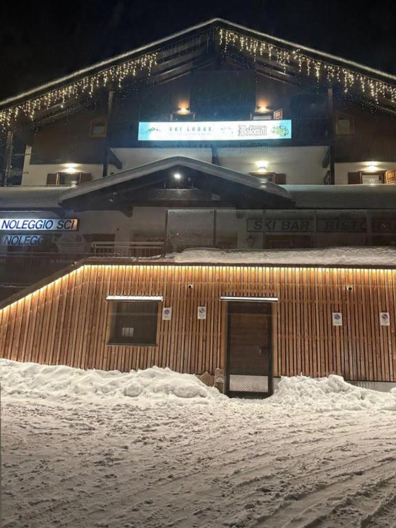 a building with a door in the snow at night at Ski Lodge Pampeago in Tesero