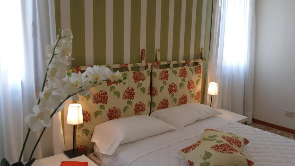 1 dormitorio con 1 cama blanca y 2 lámparas en Casa delle Ortensie, en Venecia