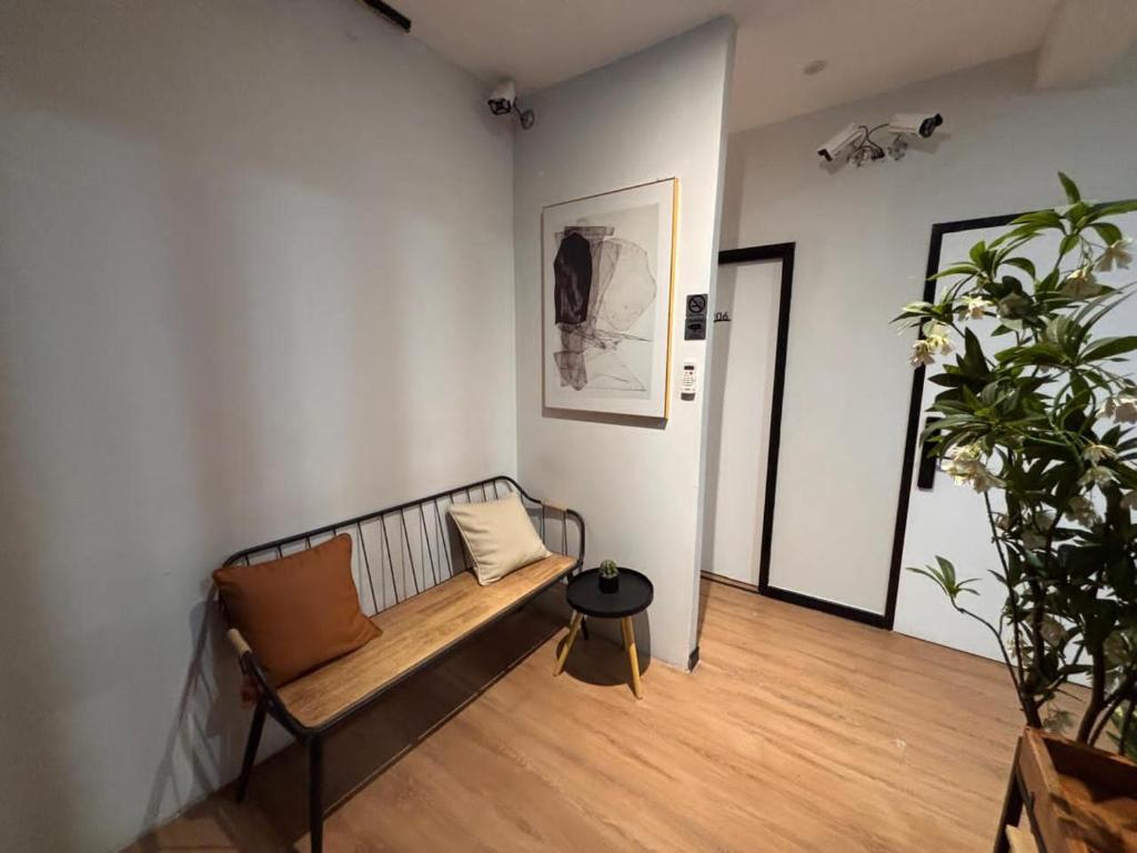 a room with a bench and a potted plant at Mini Urban Guest House in Kampong Pasang