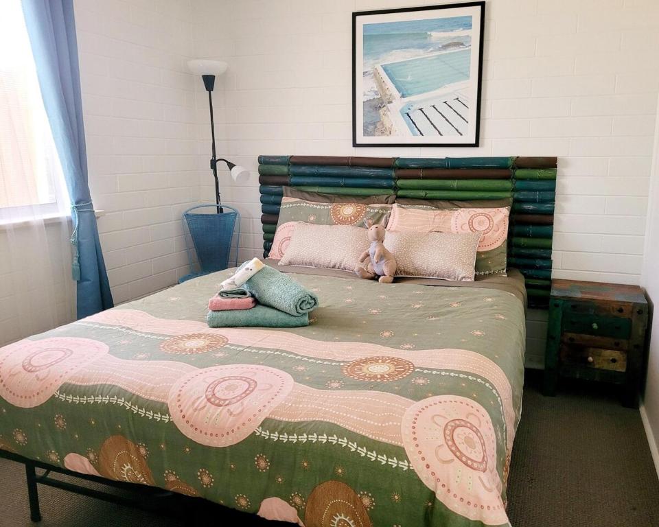 a bedroom with a bed with two stuffed animals on it at The Peppercorn Shack in Kingscote