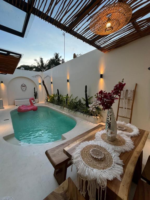 a swimming pool in a patio with a table and a table sidx sidx at Sampai Villa Kama in Ngaglik