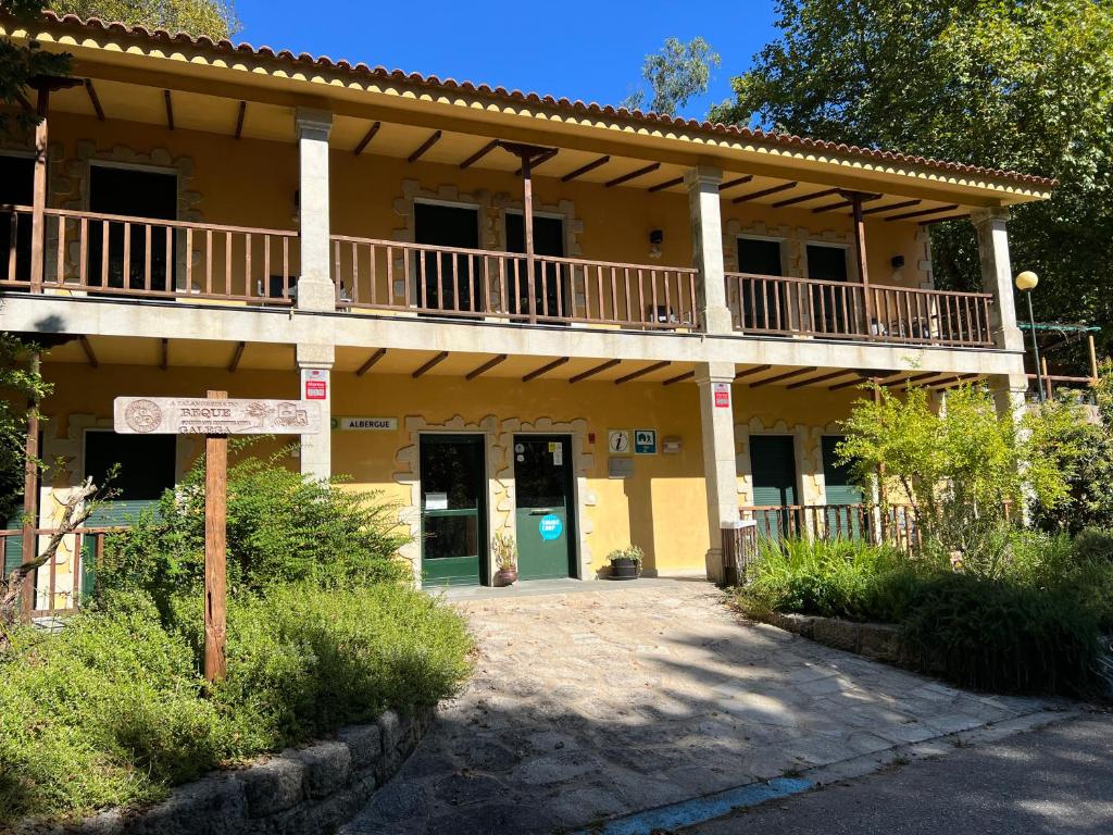 a large yellow building with a balcony on it at Albergue O Beque in Moaña