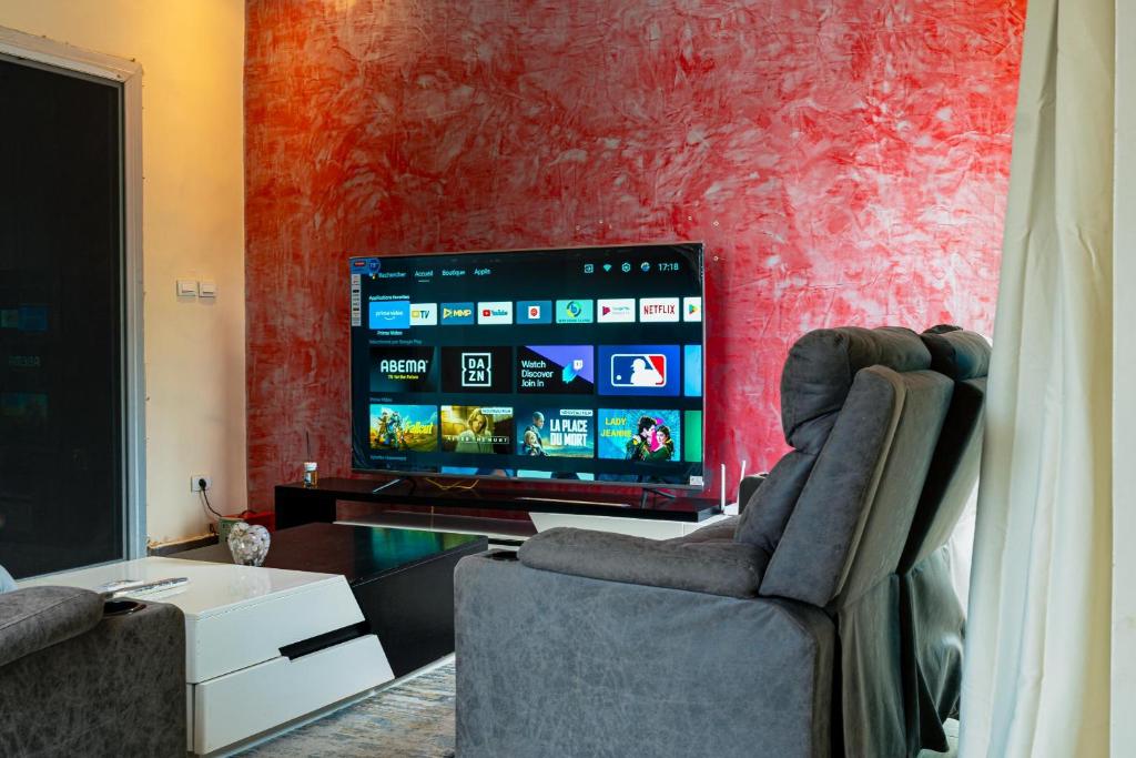 a living room with two chairs and a flat screen tv at Camara Homes1 in Saint-Louis