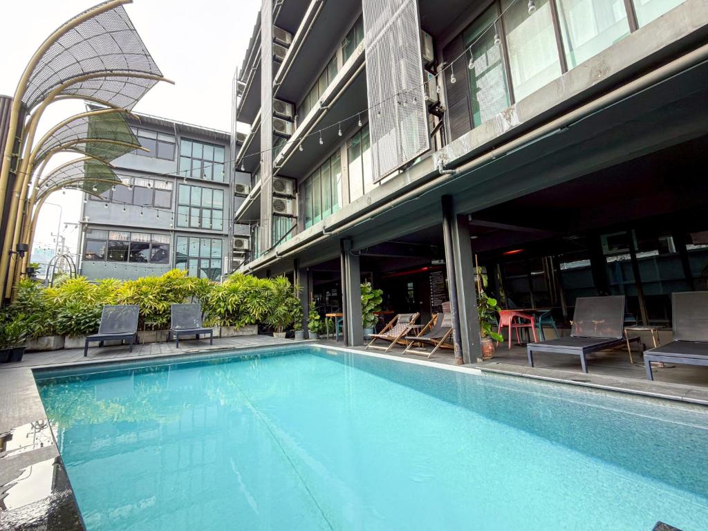 a large swimming pool in front of a building at Hotel Ordinary Bangkok in Bangkok