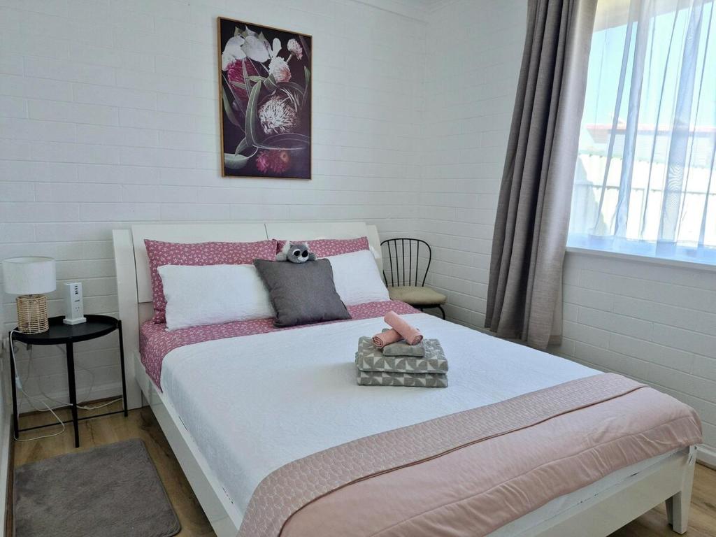 a bedroom with a bed with a teddy bear on it at Brownlow Beach Shack in Kingscote