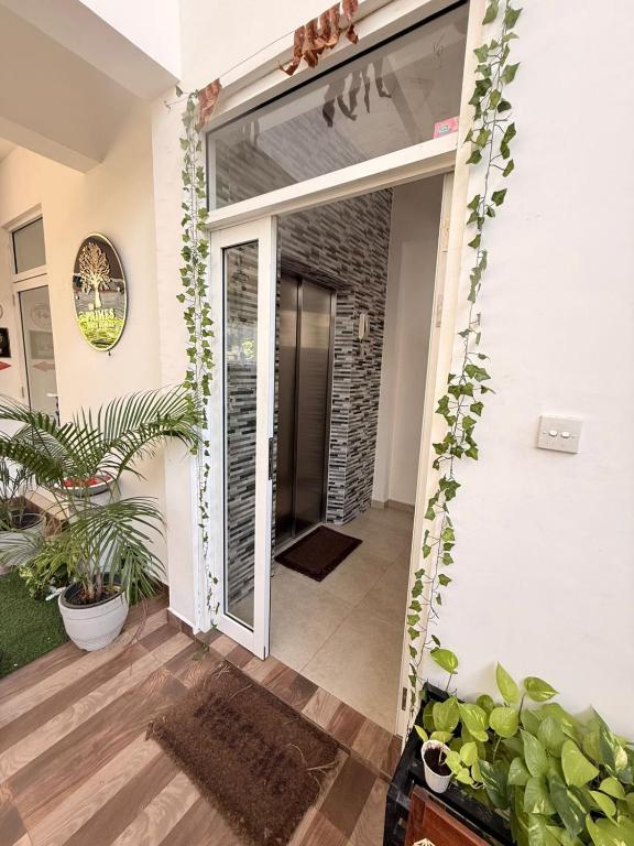 a sliding glass door leading into a hallway with plants at Wellness Residencies in Colombo