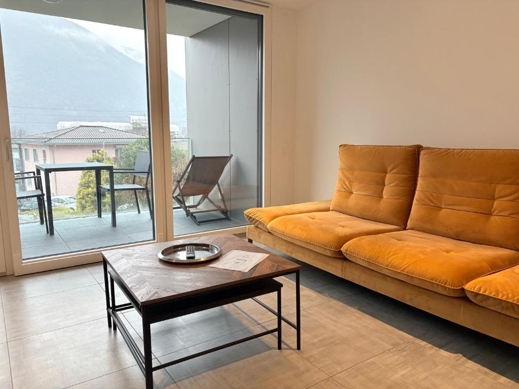 a living room with an orange couch and a table at LabPark enjoy Melano in Melano