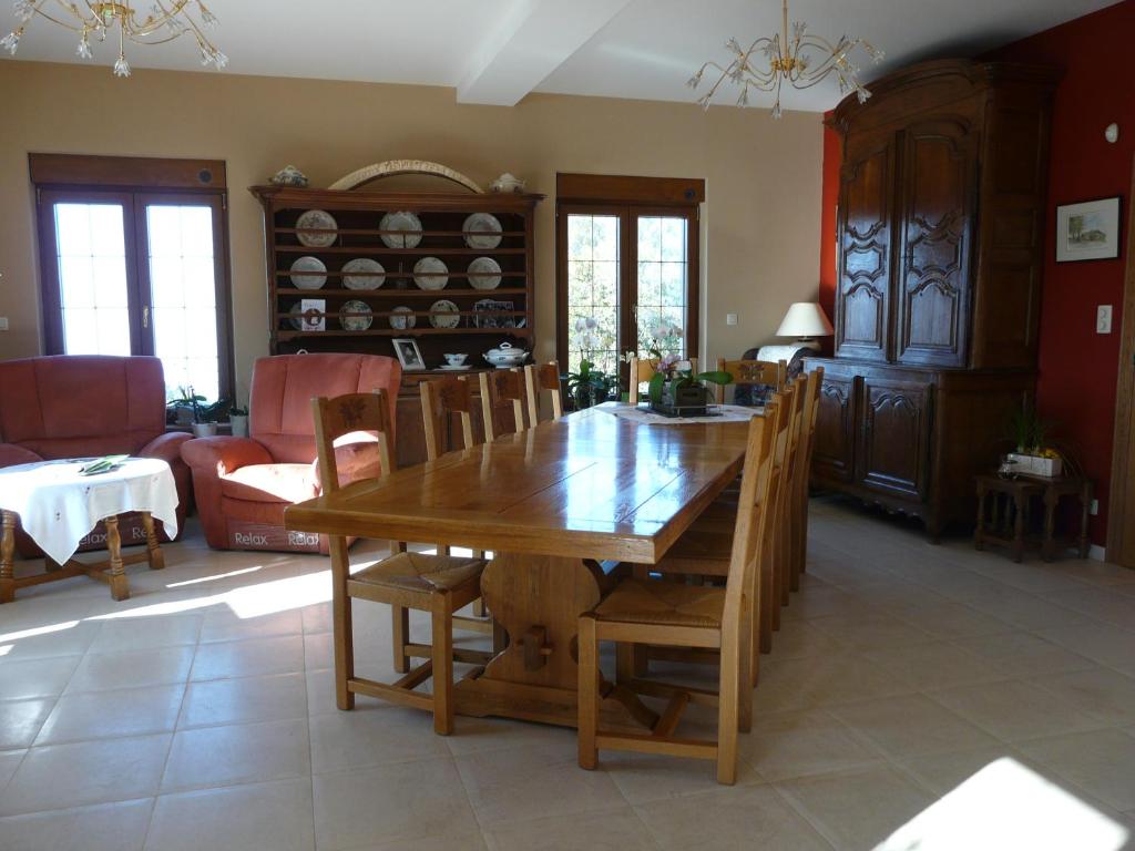 comedor con mesa de madera y sillas en L'orchidée, en Rochehaut