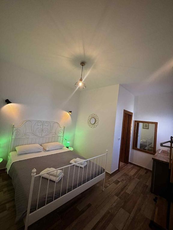 a bedroom with a bed with green lights at BlackBeach village in Perissa